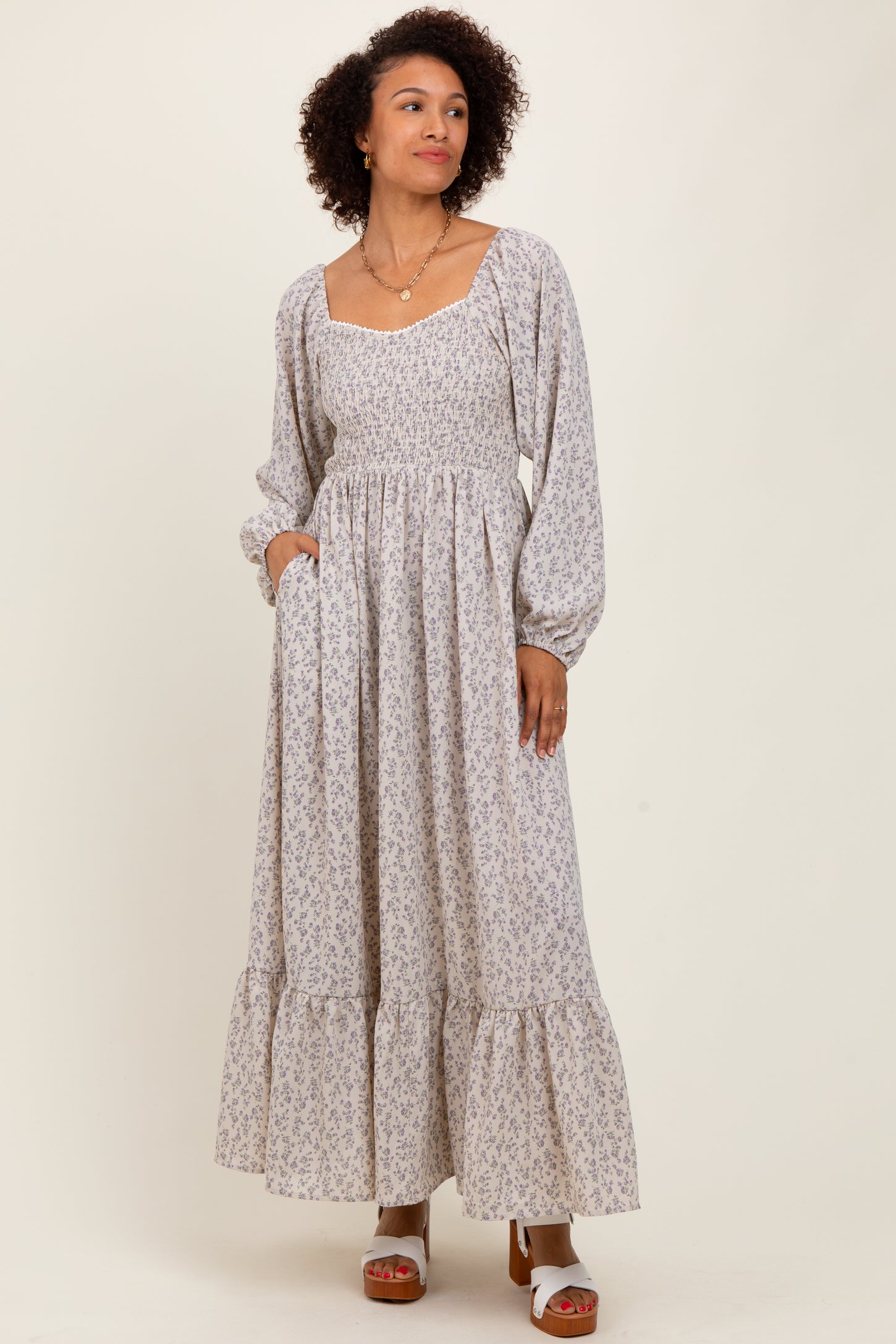 woman wearing a long sleeve floral print maxi dress with a square neckline and tiered ruffle hem