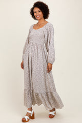 woman wearing a long floral maxi dress with long sleeves and a tiered skirt, posing and smiling