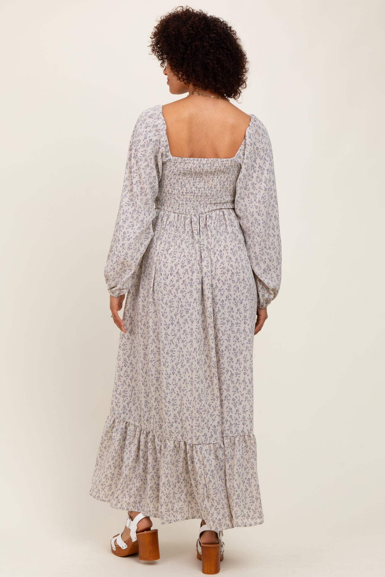 woman wearing a pastel floral maxi dress with a smocked back and long puff sleeves