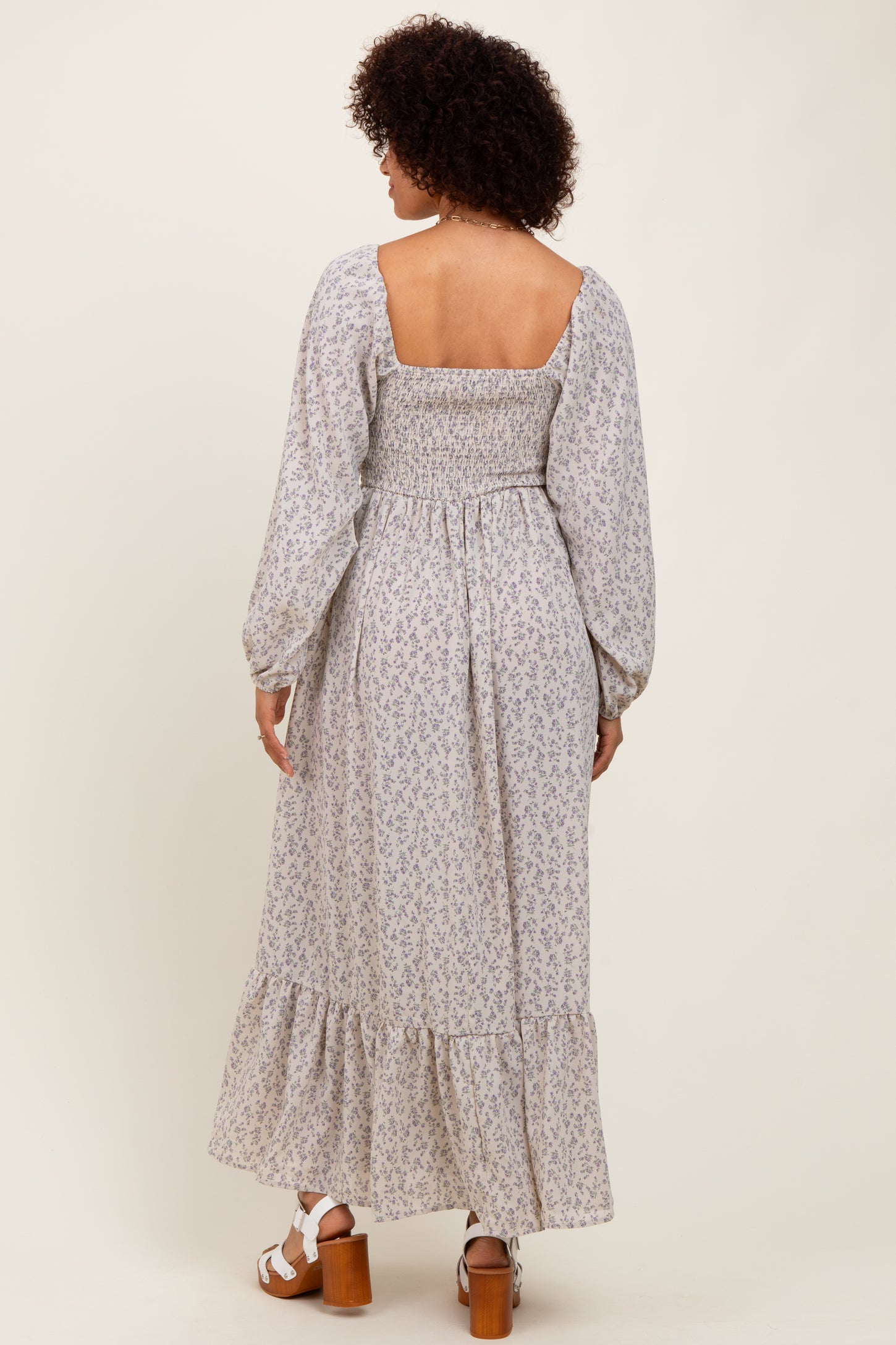 woman wearing a pastel floral maxi dress with a smocked back and long puff sleeves
