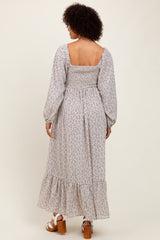 woman wearing a pastel floral maxi dress with a smocked back and long puff sleeves