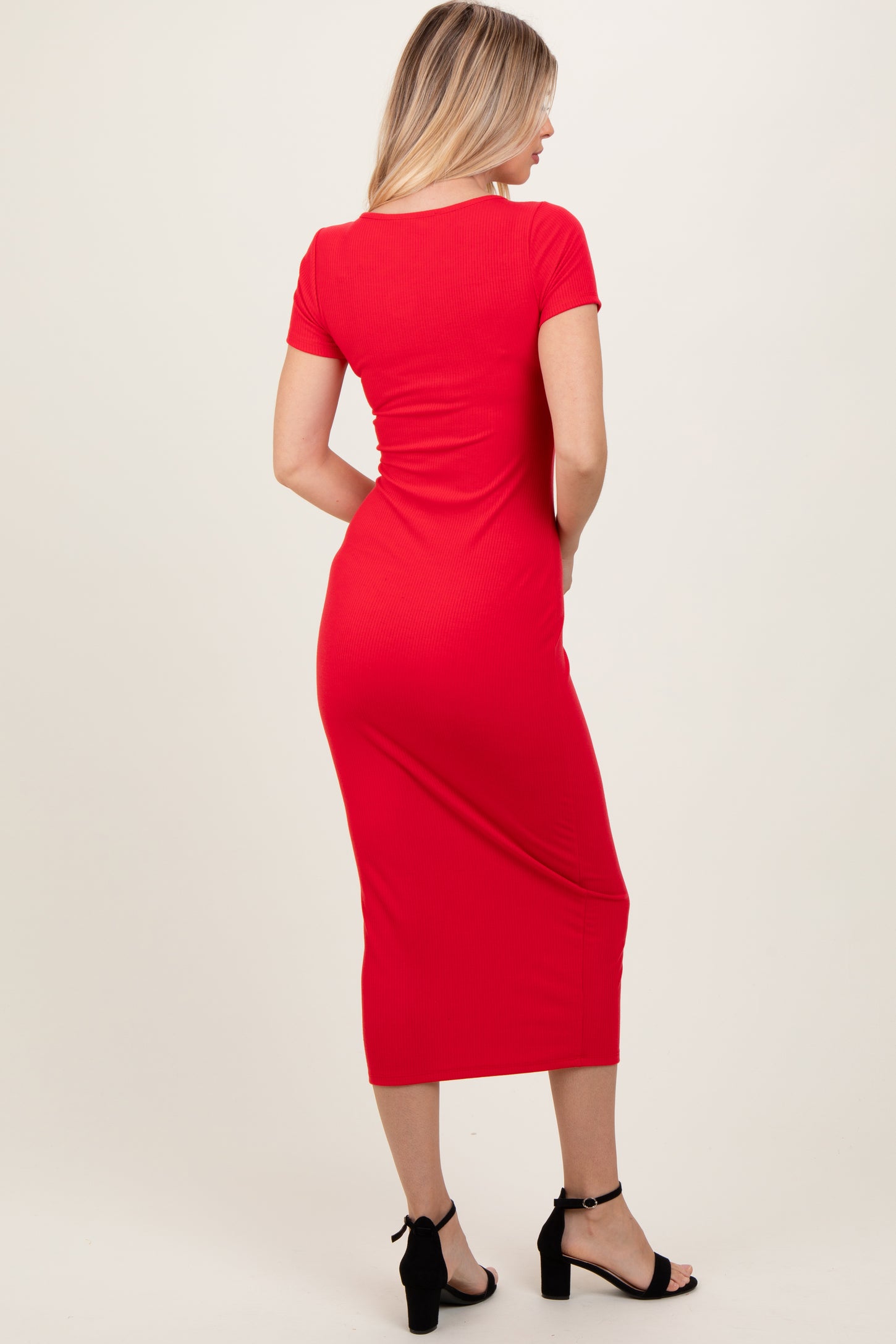 woman wearing a fitted red midi dress with short sleeves, viewed from the back