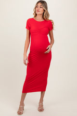 woman wearing a red short sleeve maternity dress with ruching and a visible baby bump