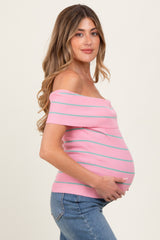 woman wearing a pink striped off-shoulder maternity top and holding her baby bump