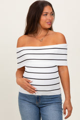 woman wearing a white and navy striped off-the-shoulder maternity top and holding her baby bump