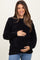 woman wearing a black maternity sweater with a cozy texture and holding her baby bump