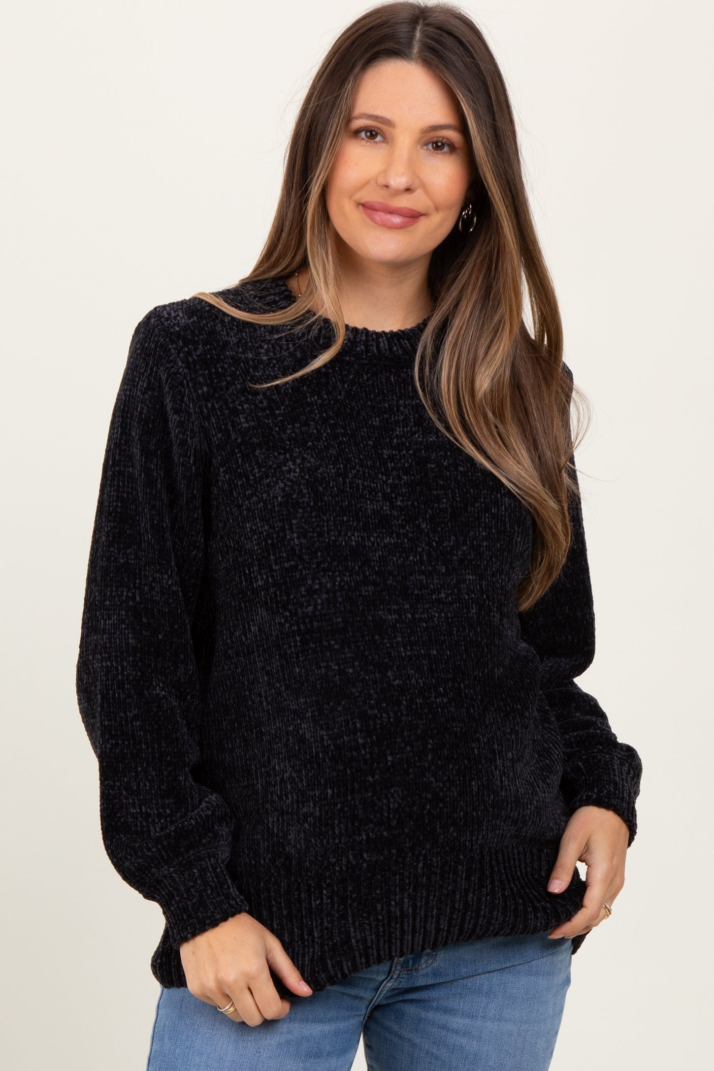 woman wearing a black textured maternity sweater with a rounded neckline and long sleeves