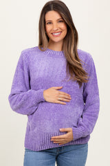 woman wearing a purple textured maternity sweater and holding her baby bump