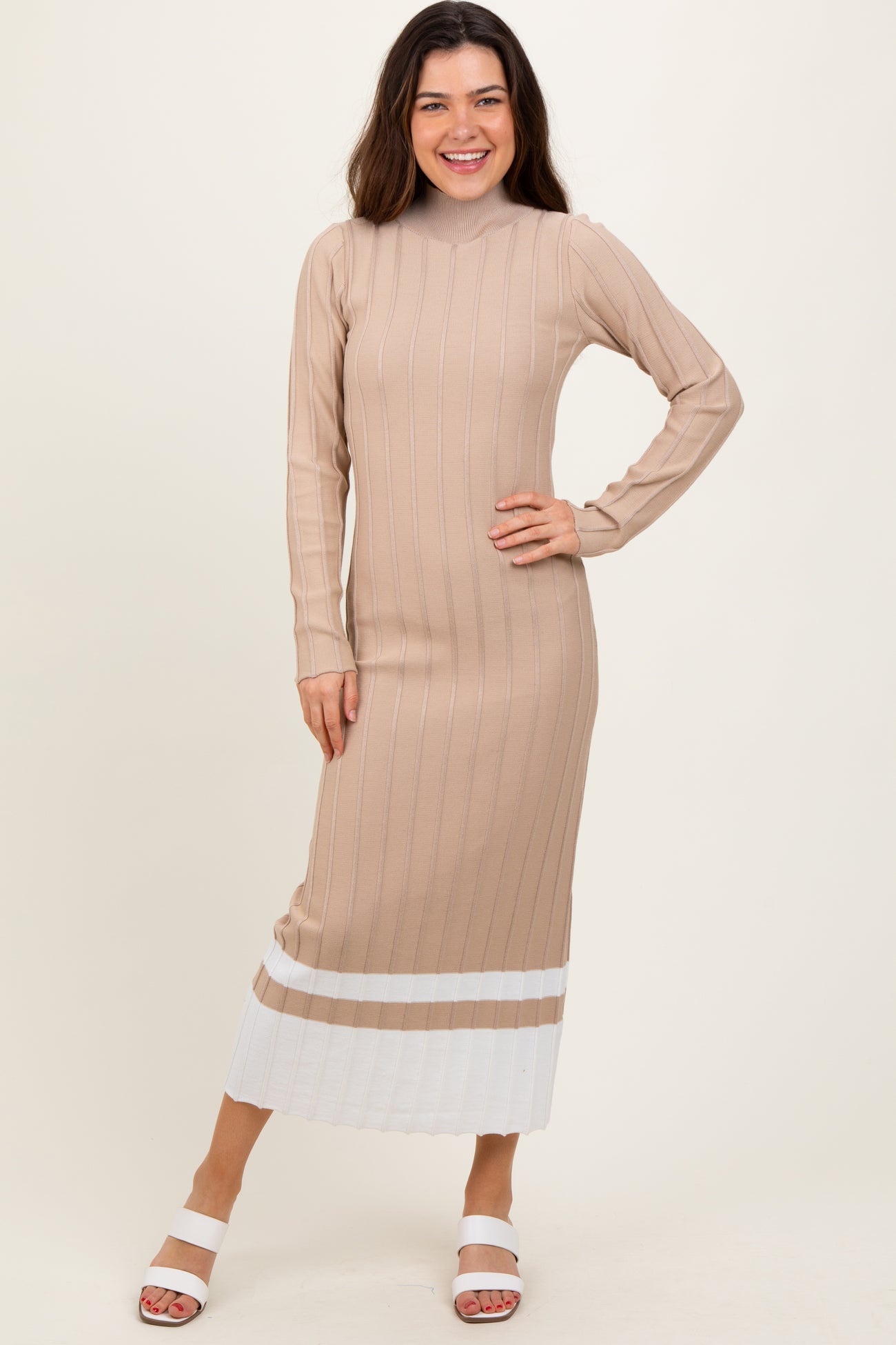 woman wearing a beige ribbed long sleeve midi dress with white stripes at the hem and smiling