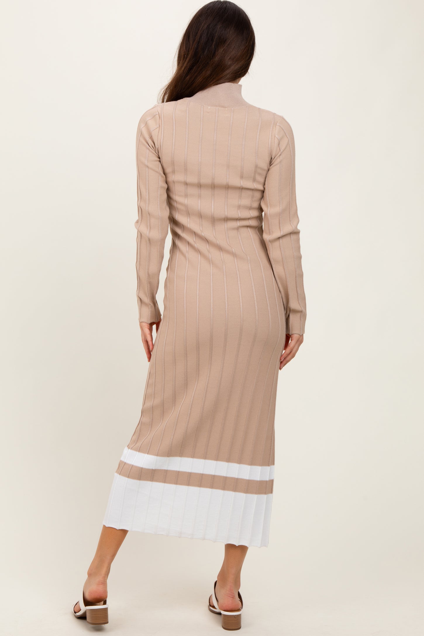 woman wearing a beige ribbed midi dress with white striped details and a fitted silhouette, seen from the back