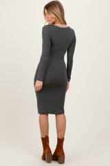 woman wearing a grey long sleeve fitted midi dress with a scoop back, paired with brown ankle boots