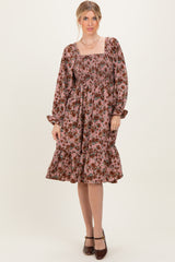 woman wearing a pink floral smocked midi dress with long sleeves and ruffled hemline
