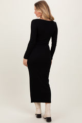 woman wearing a black ribbed long sleeve maxi dress, view from the back showcasing a fitted silhouette