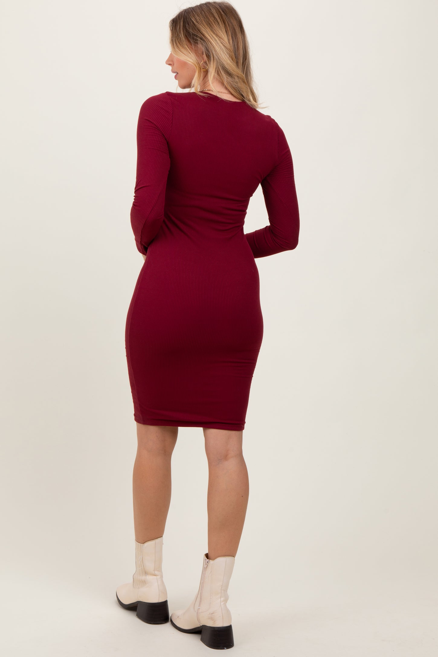 woman wearing a fitted burgundy ribbed long sleeve dress, shown from the back