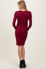 woman wearing a burgundy long sleeve fitted maternity dress viewed from the back