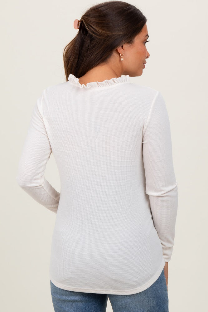 woman wearing a white ribbed maternity top with ruffle detailing at the back
