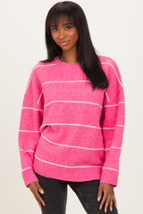 woman wearing a pink striped sweater with a relaxed fit and long sleeves