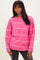 woman wearing a pink striped sweater with a relaxed fit and long sleeves