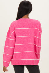 woman wearing a bright pink striped sweater with a relaxed fit, showing the back view and long sleeves