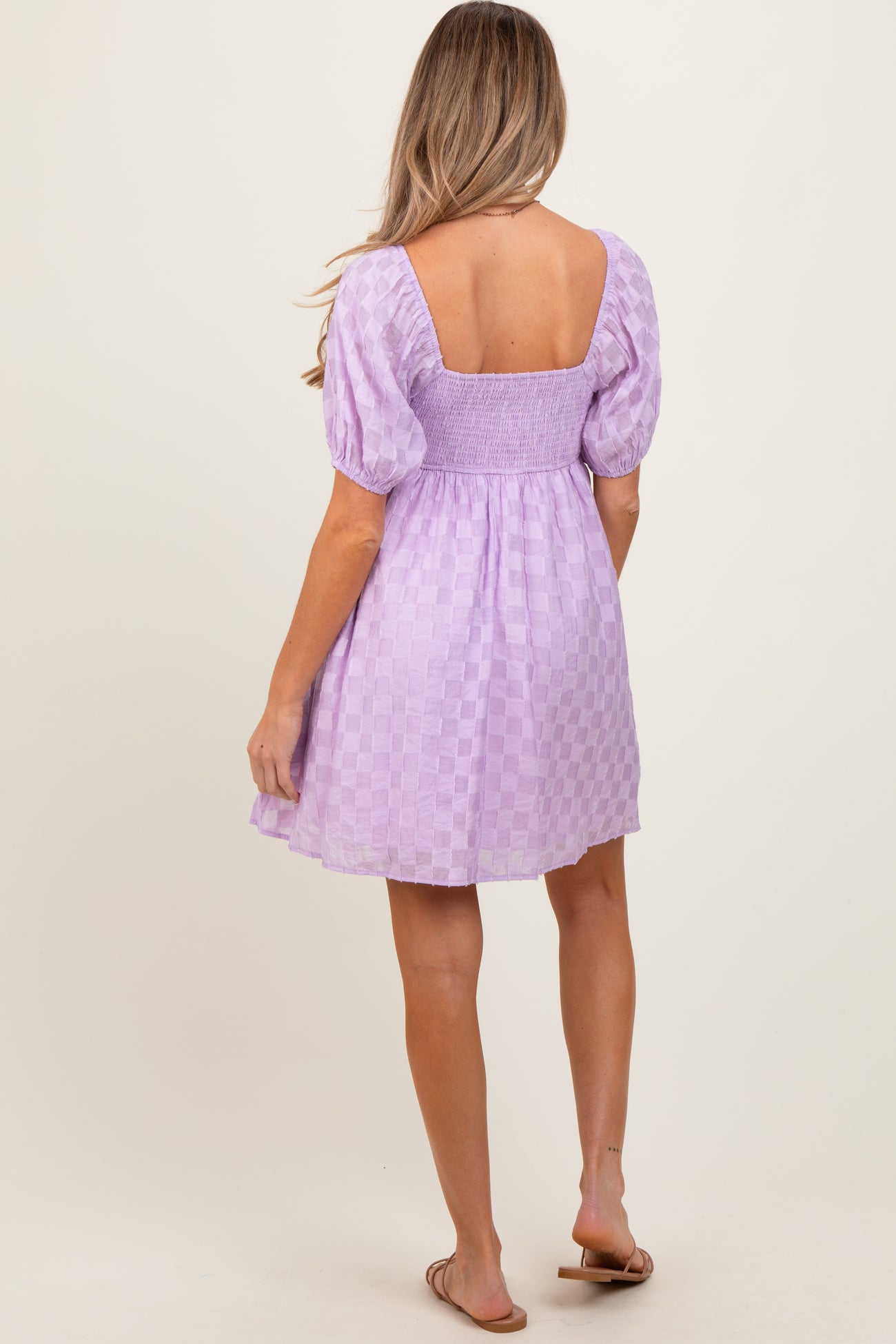woman wearing a lavender maternity dress with puff sleeves and a square back design, showcasing a baby bump