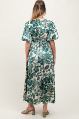 woman wearing a green and white floral print maternity dress with puff sleeves, shown from the back