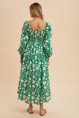 woman wearing a green floral maxi dress with puff sleeves and a square neckline, seen from the back