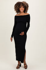 woman wearing a black off-the-shoulder ribbed maternity dress with a side slit and holding her baby bump