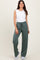 woman wearing a white sleeveless top and green drawstring wide-leg pants
