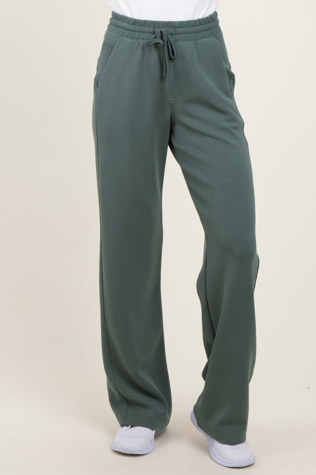 woman wearing green wide-leg sweatpants with an elastic waistband and side pockets