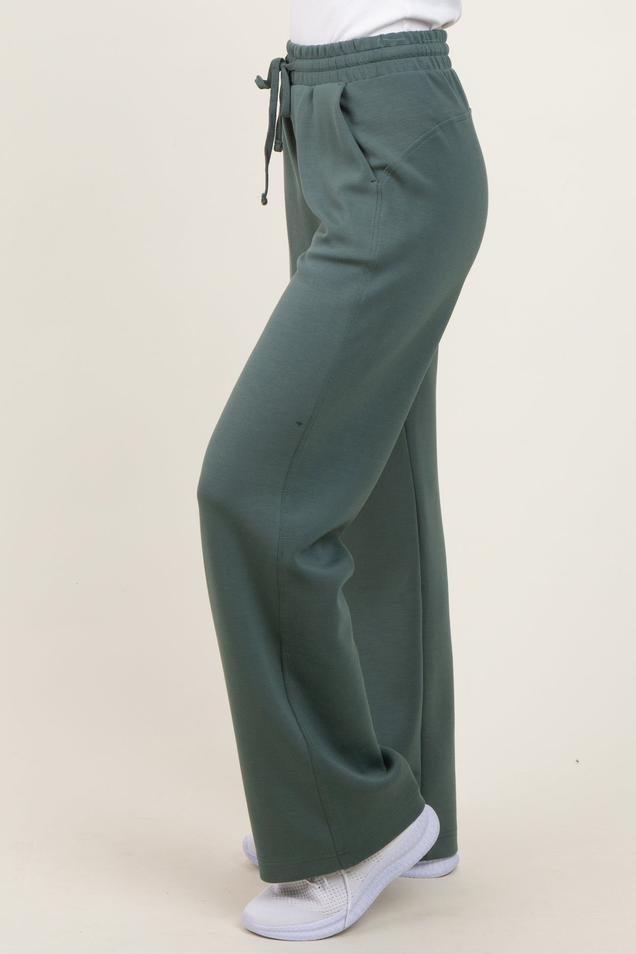woman wearing green elastic waist sweatpants with a relaxed fit and side pockets