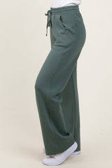 woman wearing green elastic waist sweatpants with a relaxed fit and side pockets