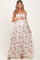 woman wearing a floral print maternity maxi dress with a gathered bodice and holding her baby bump