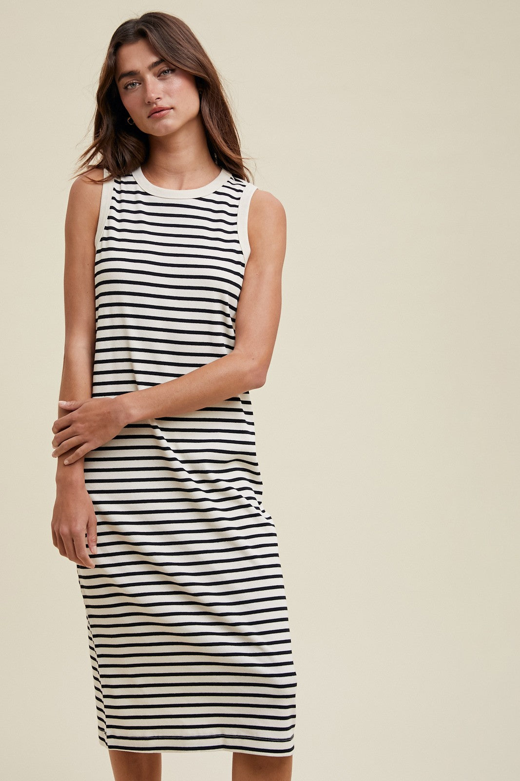 woman wearing a black and white striped sleeveless midi dress with a relaxed fit