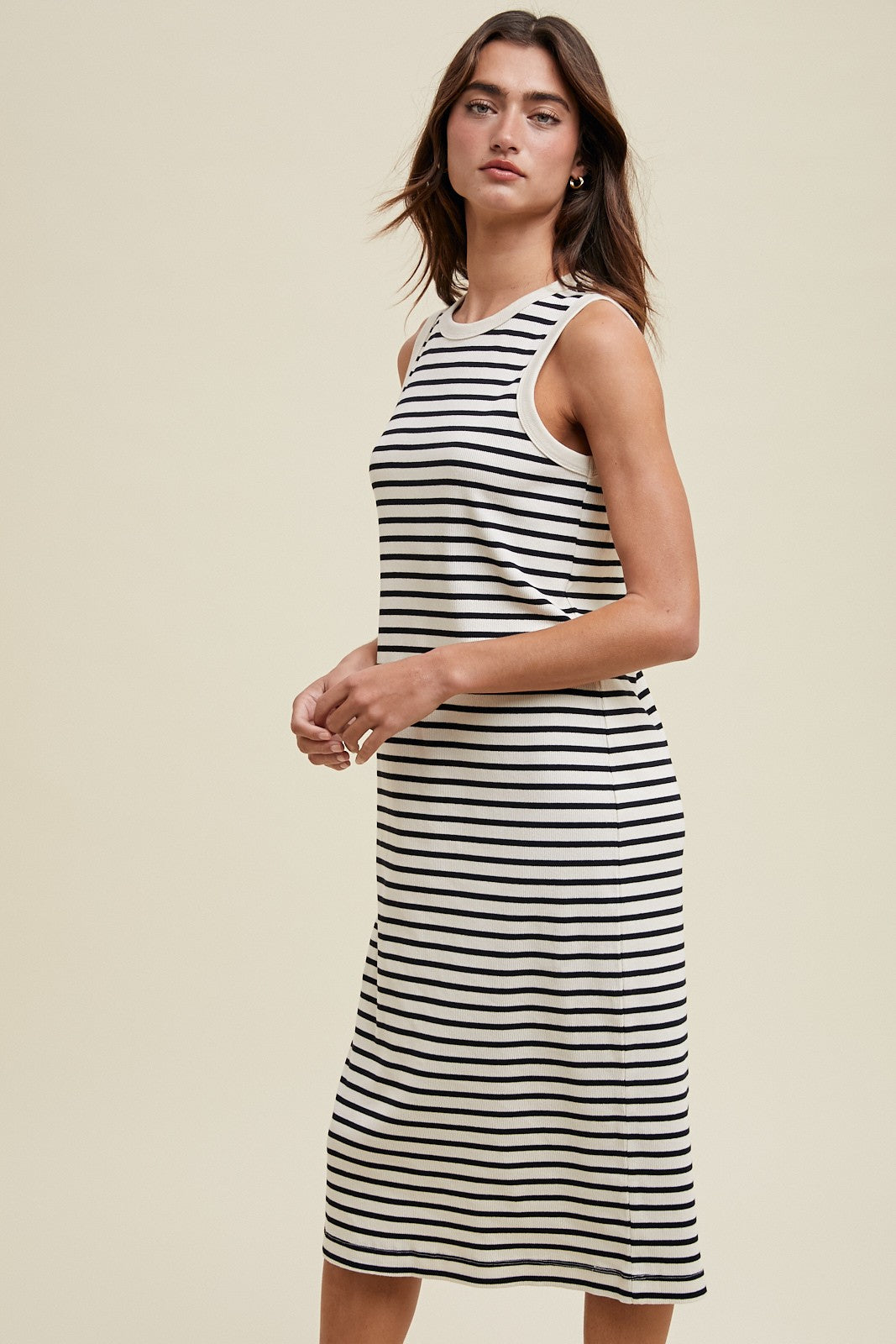 woman wearing a striped sleeveless midi dress in beige and black