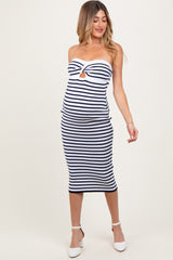 woman wearing a navy and white striped strapless maternity dress with a keyhole detail and showing her baby bump