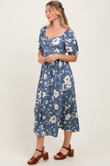 woman wearing a blue floral mid-length dress with puff sleeves and a square neckline