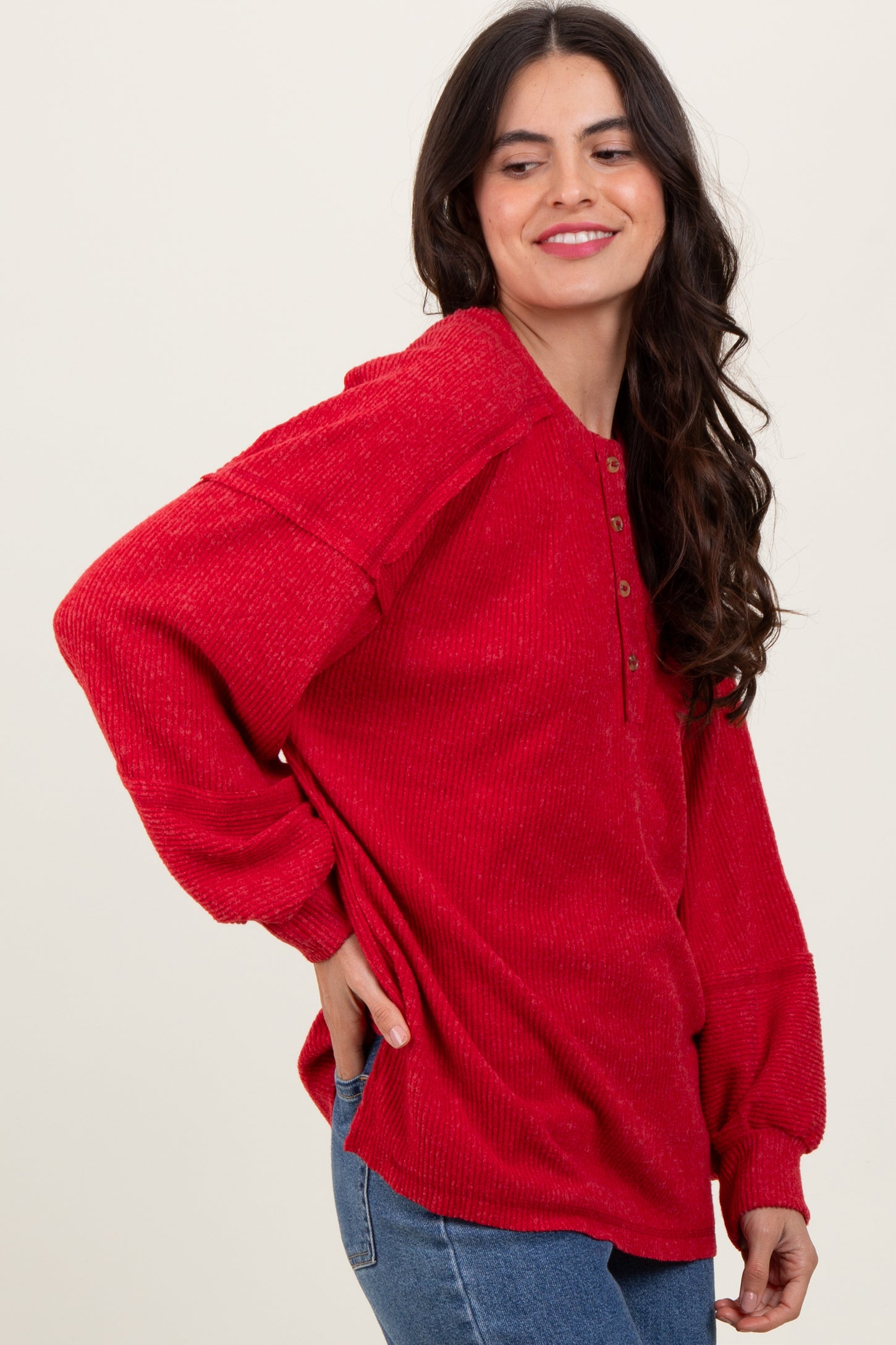 woman wearing a red long sleeve button-up top with a relaxed fit and dropped shoulders