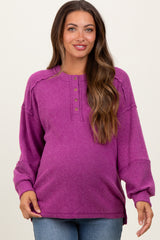 woman wearing a purple ribbed maternity top with button details and a relaxed fit, highlighting her baby bump