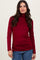 woman wearing a burgundy long sleeve turtleneck top with a fitted silhouette and soft fabric