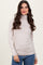 woman wearing a beige long sleeve turtleneck top with a fitted style and soft fabric