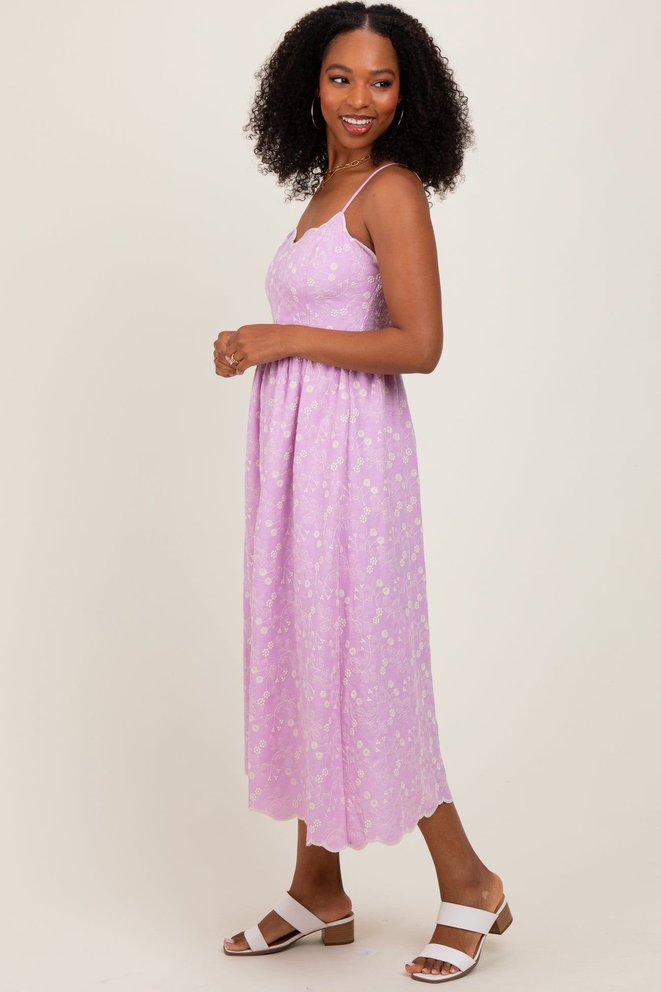 woman wearing a lavender floral midi dress with adjustable spaghetti straps and open sandals