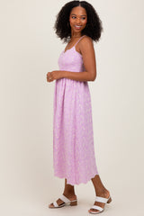 woman wearing a lavender floral midi dress with adjustable spaghetti straps and open sandals