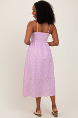 woman wearing a lavender floral midi dress with adjustable straps and a smocked bodice, shown from the back