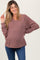 woman wearing a mauve v-neck maternity sweater with a relaxed fit and long sleeves, showing her baby bump