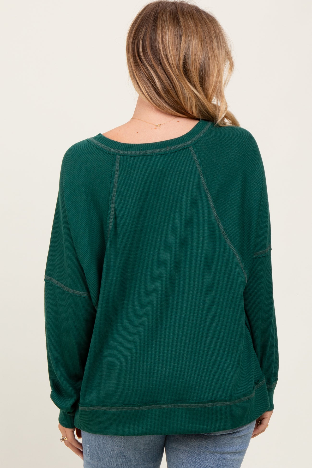 woman wearing a green oversized ribbed sweater with a relaxed fit and back seam detailing