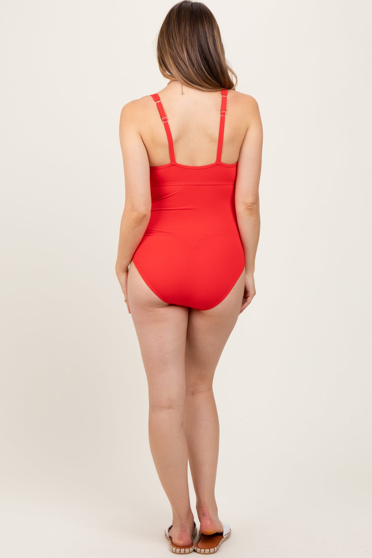 woman wearing a red maternity swimsuit with adjustable straps shown from the back