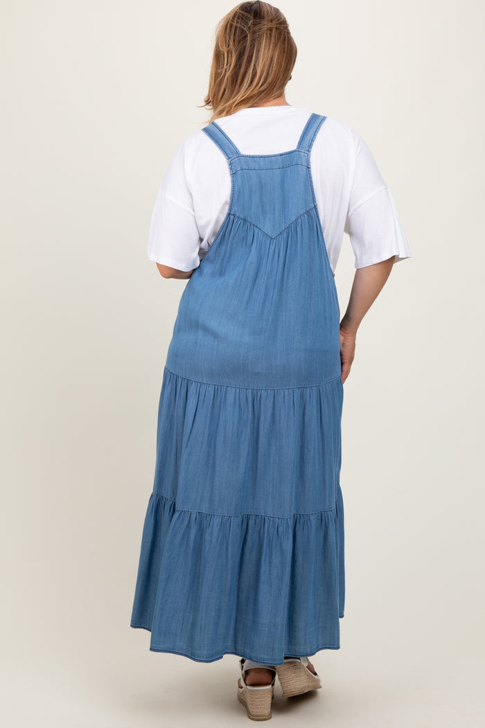 woman wearing a maternity plus blue denim tiered maxi dress with a relaxed fit and adjustable straps, viewed from the back