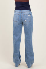 woman wearing distressed light blue maternity jeans, viewed from the back