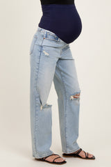 woman wearing blue distressed maternity jeans with a navy belly band and visible baby bump