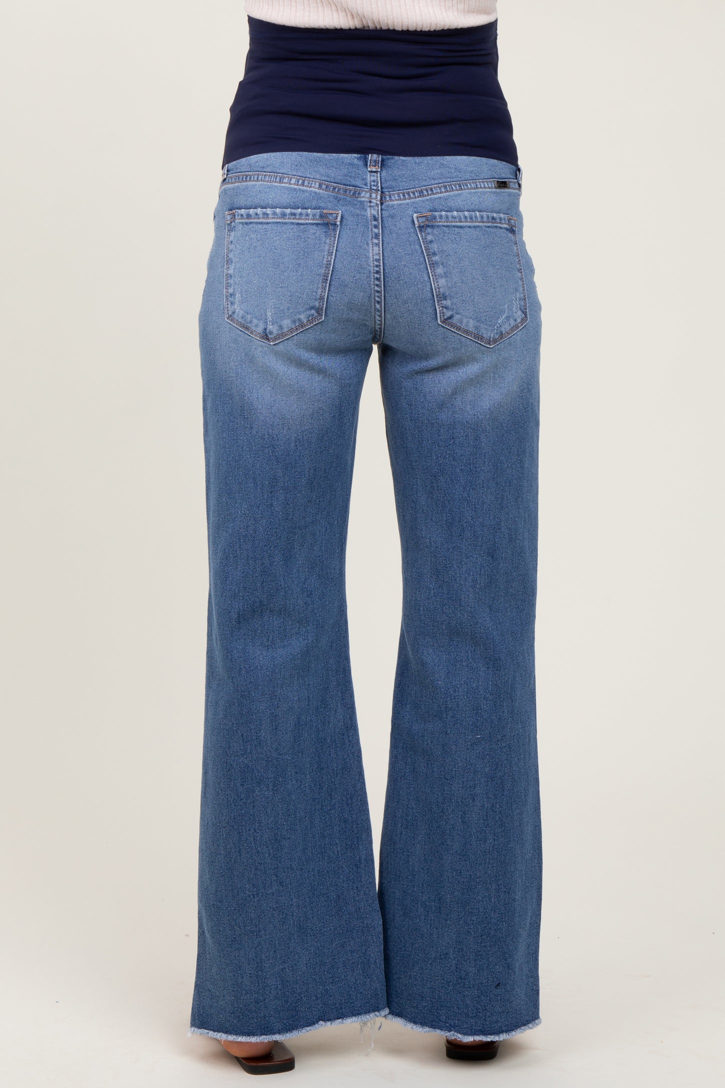 woman wearing a pair of blue maternity wide-leg jeans, viewed from the back